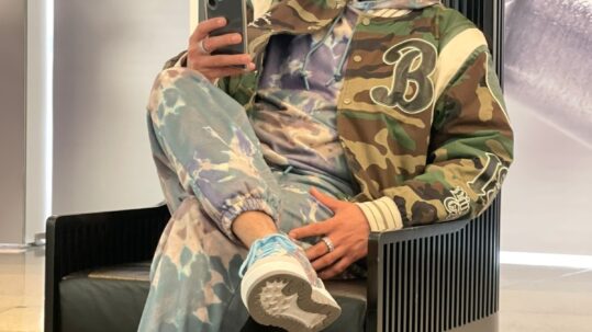 A photograph of Rajwinder (Raj) Singh smiling while sitting in a chair