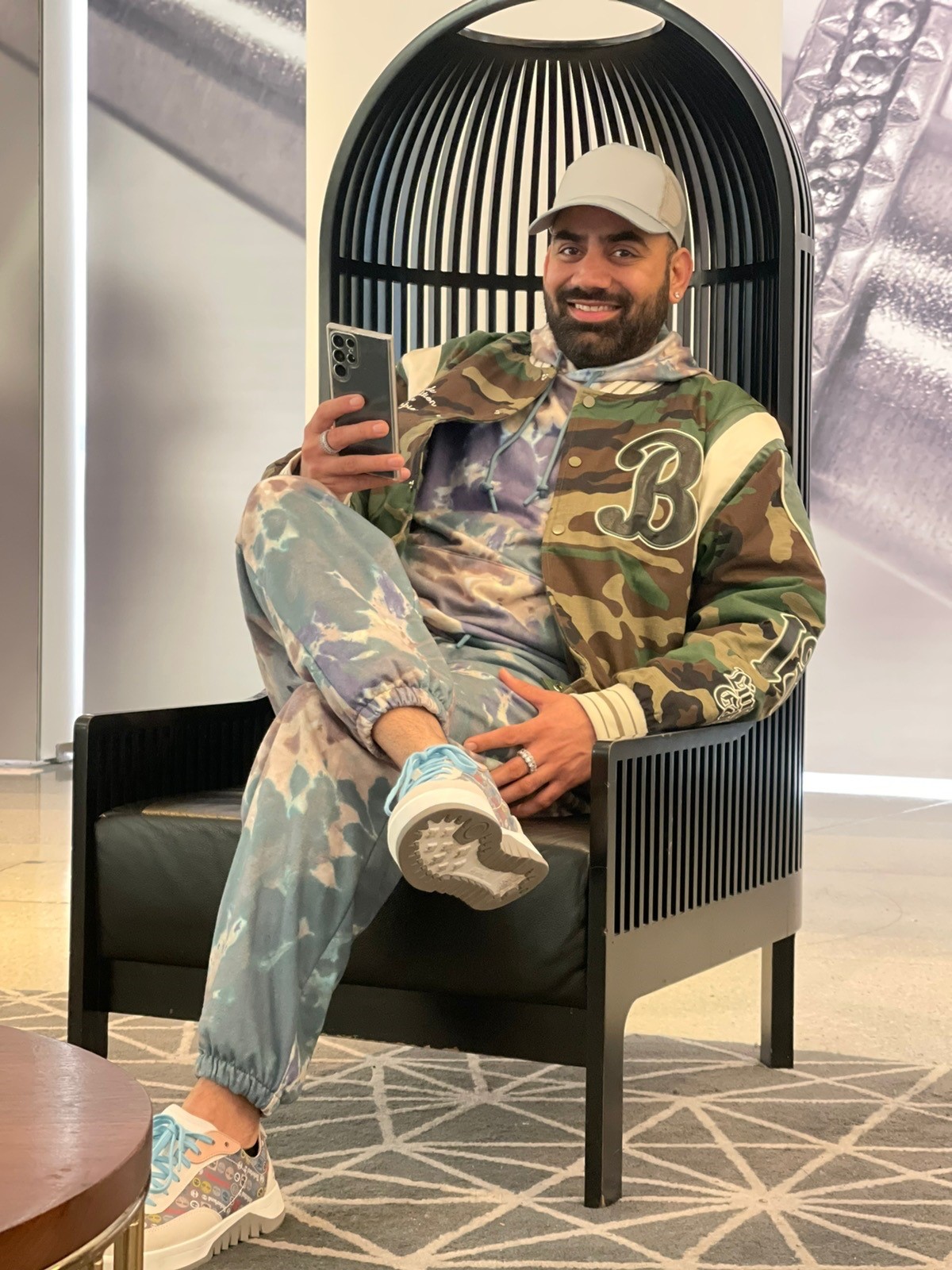 A photograph of Rajwinder (Raj) Singh smiling while sitting in a chair